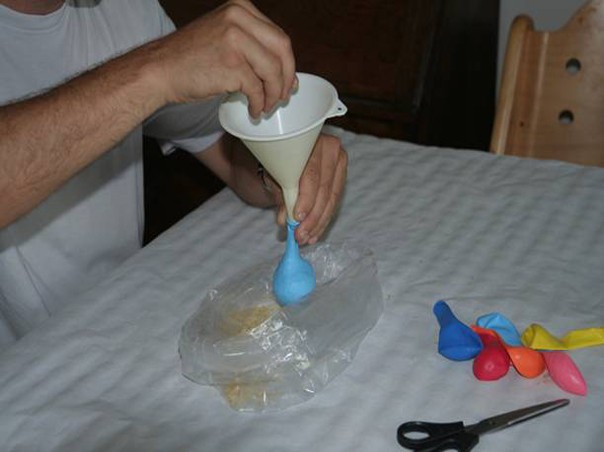 Con un embudo se rellena el globo con granos